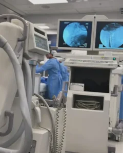 GE OEC 9900 Elite C-Arm machine in foreground with surgery team operating in background at a Florida medical facility.